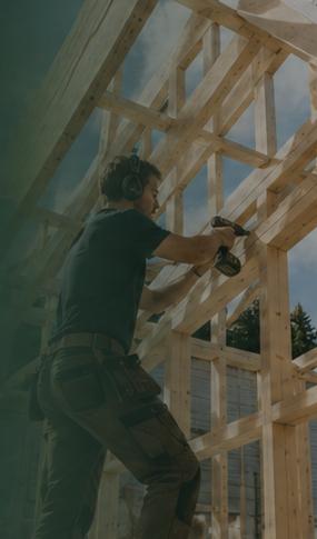 Carpenter assembling a timber frame on site